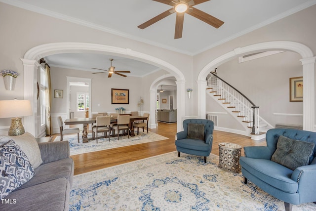 12140 Pawleys Mill Cir, Raleigh, NC 27614 - living room with arched walkways, ceiling fan, wood finished floors, stairway, and decorative columns