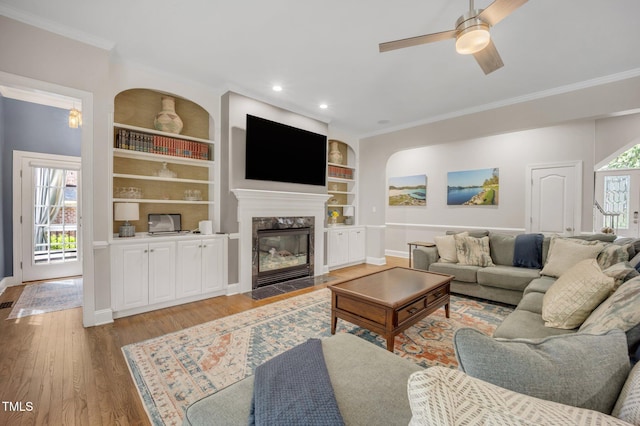 12140 Pawleys Mill Cir, Raleigh, NC 27614 - living room featuring crown molding, baseboards, ceiling fan, light wood finished floors, and a premium fireplace