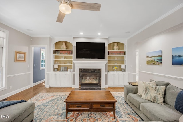 12140 Pawleys Mill Cir, Raleigh, NC 27614 - living room featuring ceiling fan, a fireplace, wood finished floors, built in features, and baseboards