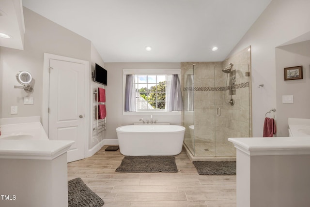 12140 Pawleys Mill Cir, Raleigh, NC 27614 - full bath with vaulted ceiling, a soaking tub, a stall shower, vanity, and wood finished floors