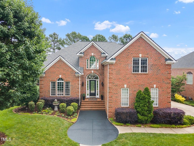 12140 Pawleys Mill Cir, Raleigh, NC 27614 - traditional-style home with brick siding, a front yard, and roof with shingles