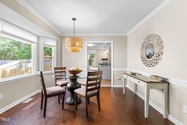 6104 New Market Way, Raleigh, NC 27609 - dining space featuring dark wood-type flooring, a chandelier, ornamental molding, plenty of natural light, and baseboards