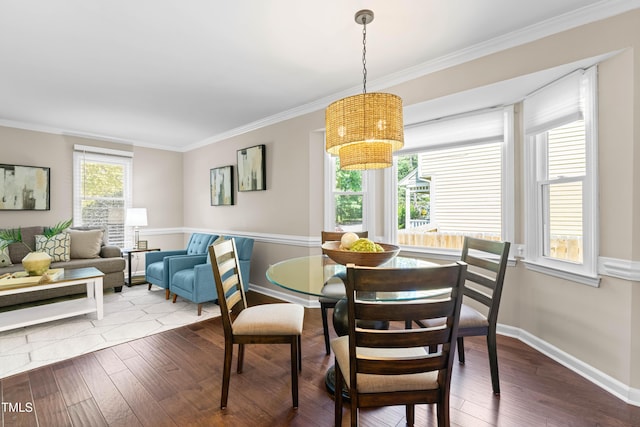 6104 New Market Way, Raleigh, NC 27609 - dining room with a chandelier, wood finished floors, crown molding, and baseboards