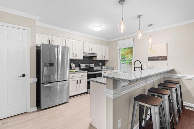 6104 New Market Way, Raleigh, NC 27609 - kitchen featuring appliances with stainless steel finishes, light wood-type flooring, a breakfast bar, a peninsula, and white cabinetry