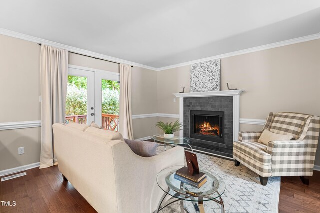 6104 New Market Way, Raleigh, NC 27609 - living room with a brick fireplace, dark wood-style floors, ornamental molding, and baseboards
