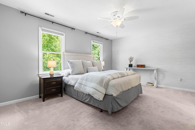 6104 New Market Way, Raleigh, NC 27609 - bedroom with light colored carpet, baseboards, wooden walls, and ceiling fan