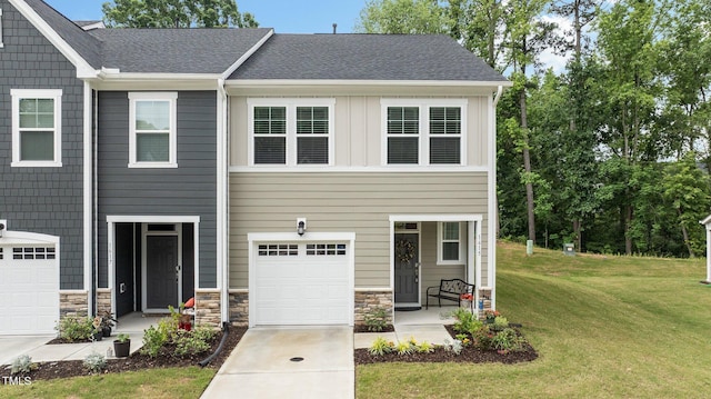 1615 Emory Ridge Way, Wake Forest, NC 27587 - view of front of property with a garage, a front lawn, concrete driveway, board and batten siding, and stone siding