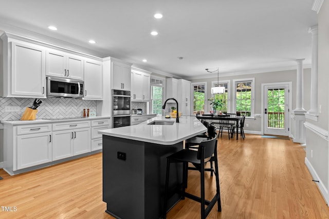 1332 Kinsdale Dr, Raleigh, NC 27615 - kitchen featuring a sink, appliances with stainless steel finishes, decorative columns, crown molding, and white cabinets