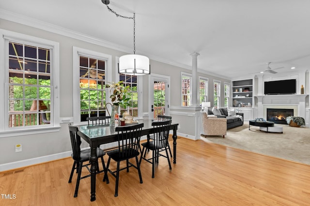 1332 Kinsdale Dr, Raleigh, NC 27615 - dining space featuring crown molding, light wood-type flooring, a glass covered fireplace, a ceiling fan, and baseboards