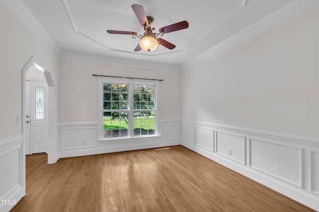 5121 Ten Point Trl, Wake Forest, NC 27587 - unfurnished room with light wood finished floors, a wainscoted wall, ceiling fan, crown molding, and arched walkways