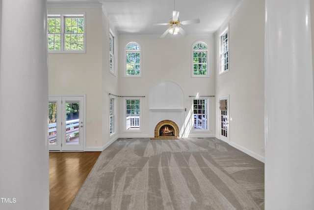 5121 Ten Point Trl, Wake Forest, NC 27587 - unfurnished living room featuring crown molding, healthy amount of natural light, baseboards, a ceiling fan, and a brick fireplace