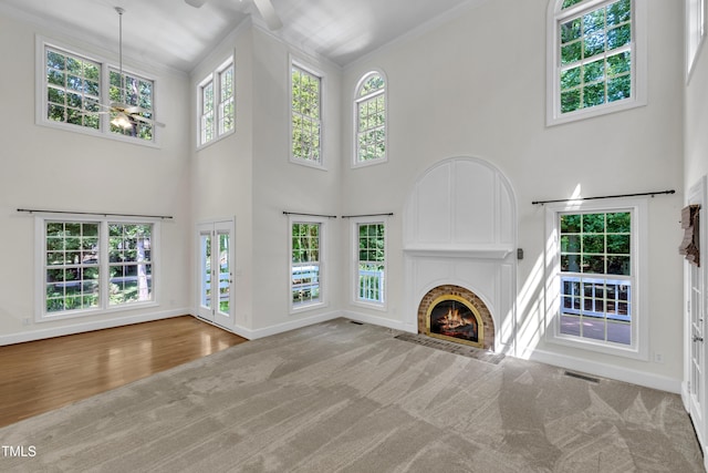 5121 Ten Point Trl, Wake Forest, NC 27587 - unfurnished living room featuring baseboards, a ceiling fan, a fireplace, a towering ceiling, and carpet flooring