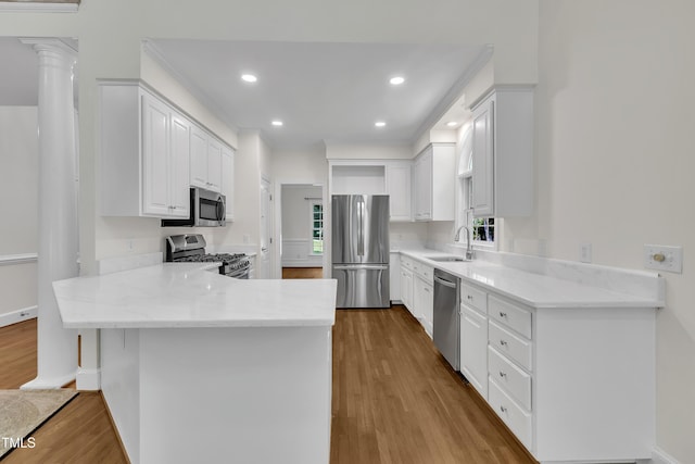 5121 Ten Point Trl, Wake Forest, NC 27587 - kitchen featuring appliances with stainless steel finishes, a peninsula, wood finished floors, a sink, and white cabinets