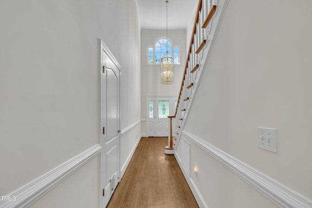 5121 Ten Point Trl, Wake Forest, NC 27587 - hall featuring a chandelier, stairs, plenty of natural light, wood finished floors, and crown molding