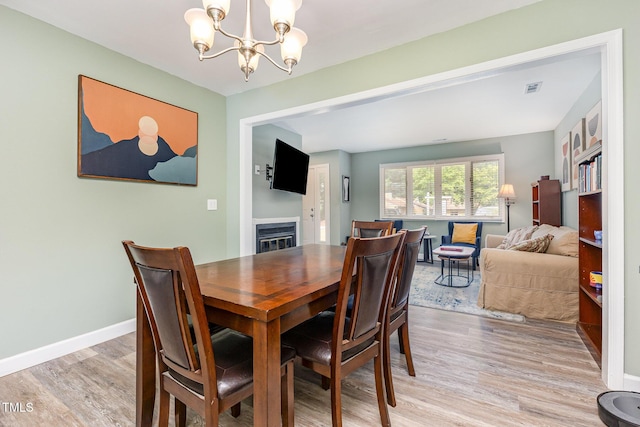 139 Hollyhock Ct, Durham, NC 27713 - dining room with a chandelier, light wood-style flooring, and baseboards