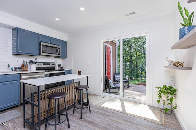 139 Hollyhock Ct, Durham, NC 27713 - kitchen featuring stainless steel appliances, blue cabinetry, light wood finished floors, ornamental molding, and recessed lighting