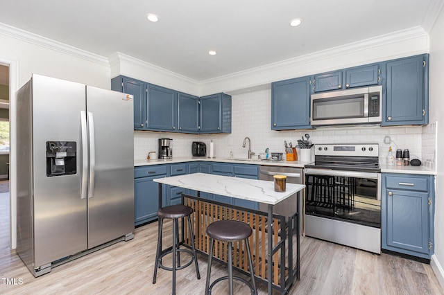 139 Hollyhock Ct, Durham, NC 27713 - kitchen featuring appliances with stainless steel finishes, blue cabinets, light wood-style floors, crown molding, and recessed lighting