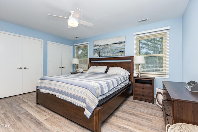 139 Hollyhock Ct, Durham, NC 27713 - bedroom featuring multiple closets, light wood-style flooring, multiple windows, and ceiling fan