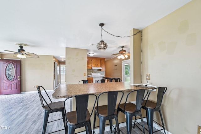 102 Pine St, Dunn, NC 28334 - kitchen featuring a ceiling fan, a peninsula, decorative backsplash, baseboards, and white electric range oven