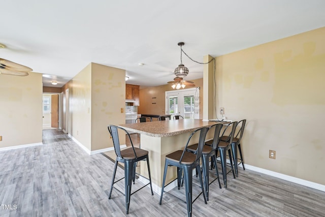 102 Pine St, Dunn, NC 28334 - kitchen with a breakfast bar, light wood finished floors, baseboards, a peninsula, and french doors