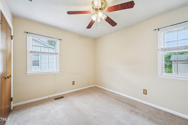 102 Pine St, Dunn, NC 28334 - spare room with healthy amount of natural light, carpet, ceiling fan, baseboards, and a textured ceiling
