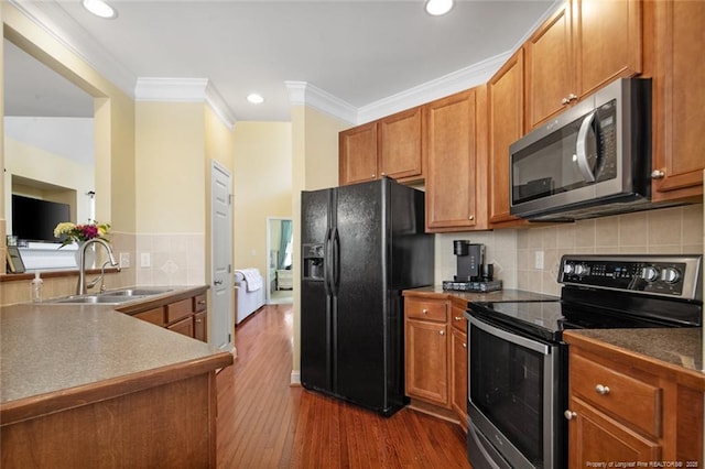 15 London Way, Spring Lake, NC 28390 - kitchen with appliances with stainless steel finishes, a sink, dark wood-type flooring, ornamental molding, and brown cabinets