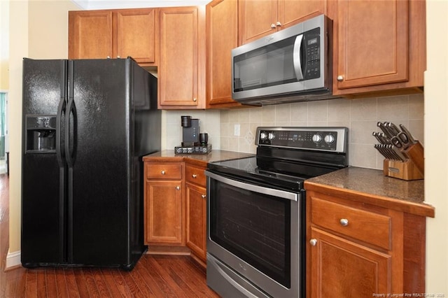 15 London Way, Spring Lake, NC 28390 - kitchen featuring stainless steel appliances, tasteful backsplash, dark wood-style flooring, dark countertops, and brown cabinets