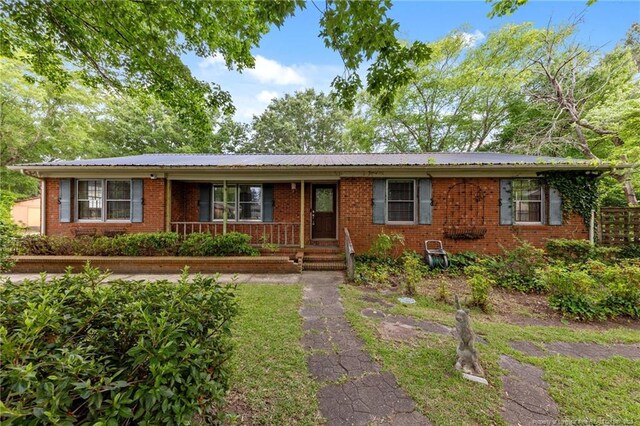 114 Birch Cir, Raeford, NC 28376 - ranch-style house featuring a porch, brick siding, and metal roof
