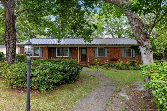 114 Birch Cir, Raeford, NC 28376 - ranch-style home with brick siding, a front lawn, and metal roof