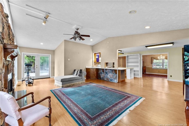 114 Birch Cir, Raeford, NC 28376 - living area with a textured ceiling, lofted ceiling, a fireplace, light wood-type flooring, and plenty of natural light