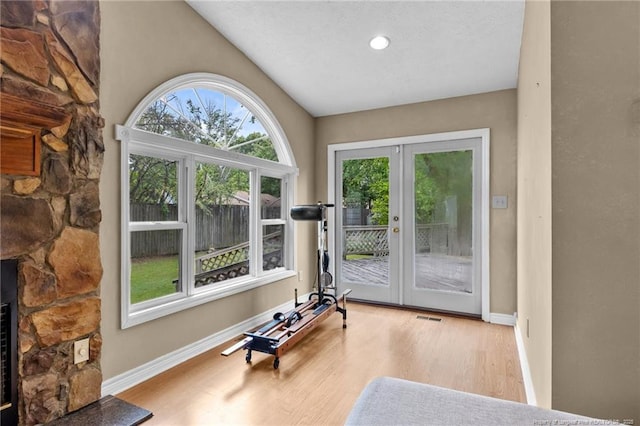 114 Birch Cir, Raeford, NC 28376 - exercise area featuring french doors, wood finished floors, lofted ceiling, baseboards, and a fireplace