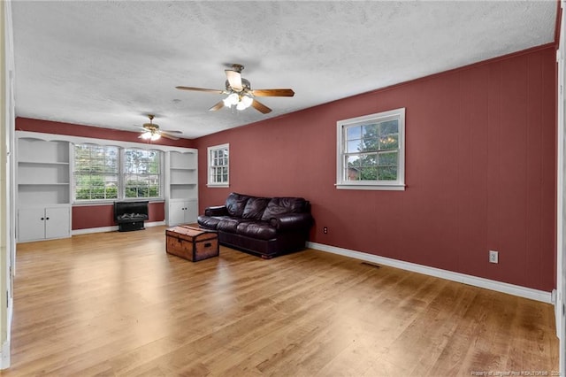 114 Birch Cir, Raeford, NC 28376 - living room featuring light wood-style flooring, a textured ceiling, healthy amount of natural light, ceiling fan, and baseboards