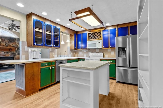 114 Birch Cir, Raeford, NC 28376 - kitchen with appliances with stainless steel finishes, light wood-type flooring, backsplash, a ceiling fan, and a peninsula