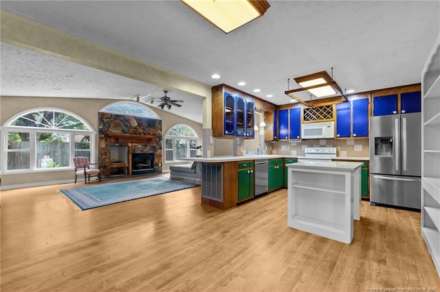 114 Birch Cir, Raeford, NC 28376 - kitchen with appliances with stainless steel finishes, open floor plan, light countertops, a stone fireplace, and open shelves