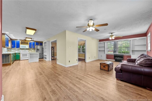 114 Birch Cir, Raeford, NC 28376 - living area featuring a textured ceiling, light wood-style floors, a ceiling fan, and baseboards