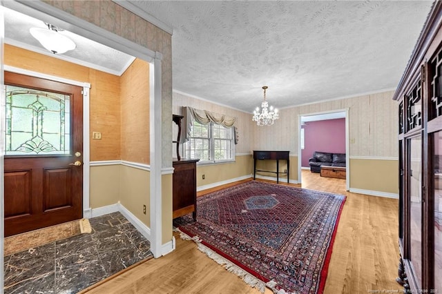 114 Birch Cir, Raeford, NC 28376 - entryway with wood finished floors, a chandelier, a textured ceiling, crown molding, and baseboards