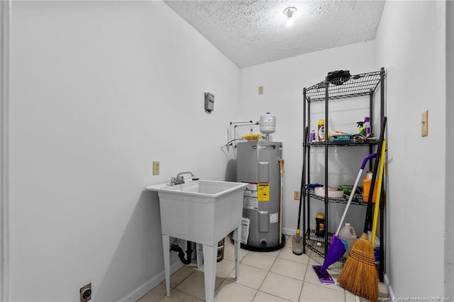 114 Birch Cir, Raeford, NC 28376 - laundry room with electric water heater, a textured ceiling, a sink, baseboards, and light tile patterned floors