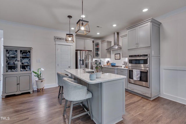 40 Bourne Dr, Franklinton, NC 27525 - kitchen featuring wall chimney exhaust hood, gray cabinetry, stainless steel appliances, backsplash, and a kitchen bar