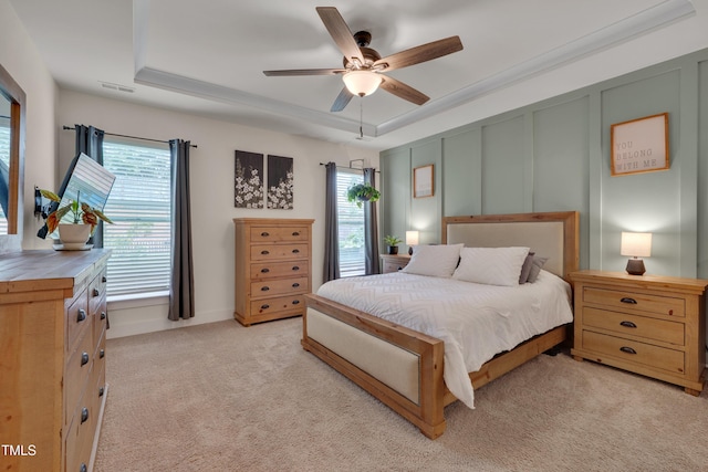 40 Bourne Dr, Franklinton, NC 27525 - bedroom featuring multiple windows, light carpet, a raised ceiling, ceiling fan, and a decorative wall