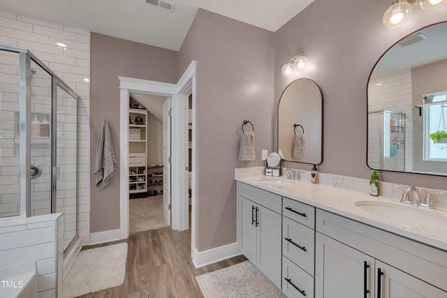 40 Bourne Dr, Franklinton, NC 27525 - full bathroom featuring wood finished floors, double vanity, a shower stall, a spacious closet, and baseboards