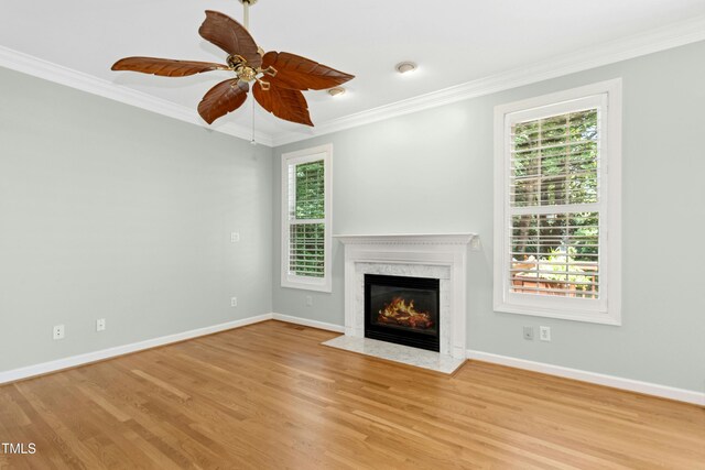 1003 Blackberry Ln, Durham, NC 27712 - unfurnished living room featuring ornamental molding, a fireplace, healthy amount of natural light, wood finished floors, and ceiling fan