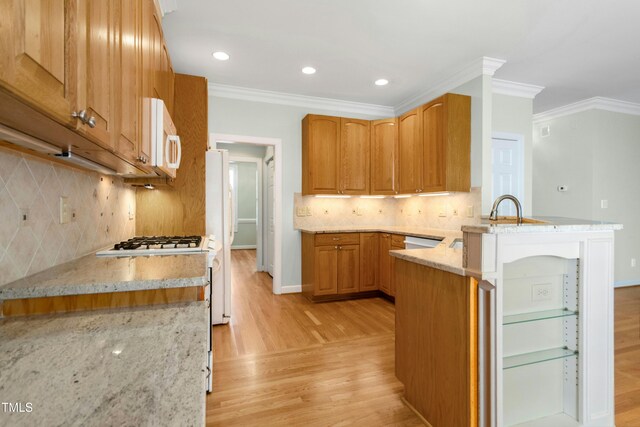 1003 Blackberry Ln, Durham, NC 27712 - kitchen with white appliances, light wood-style floors, a peninsula, light stone counters, and decorative backsplash