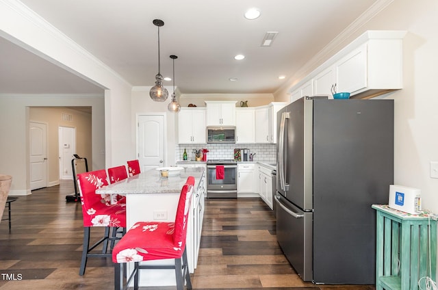 1828 Wellspring Ct, Graham, NC 27253 - kitchen featuring appliances with stainless steel finishes, white cabinets, a breakfast bar area, crown molding, and dark wood-type flooring