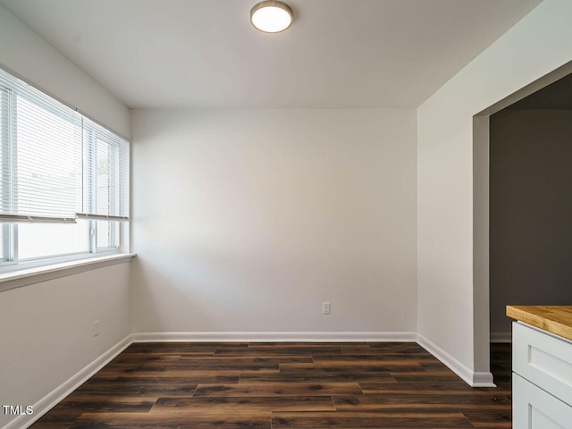 2316 Champion Ct, Raleigh, NC 27606 - unfurnished dining area with dark wood-style flooring and baseboards