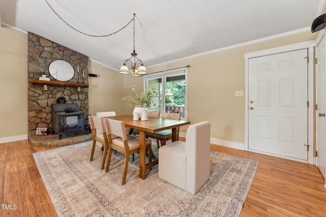 6971 Shady Creek Trl, Rougemont, NC 27572 - dining room featuring light wood finished floors, a chandelier, ornamental molding, lofted ceiling, and a wood stove