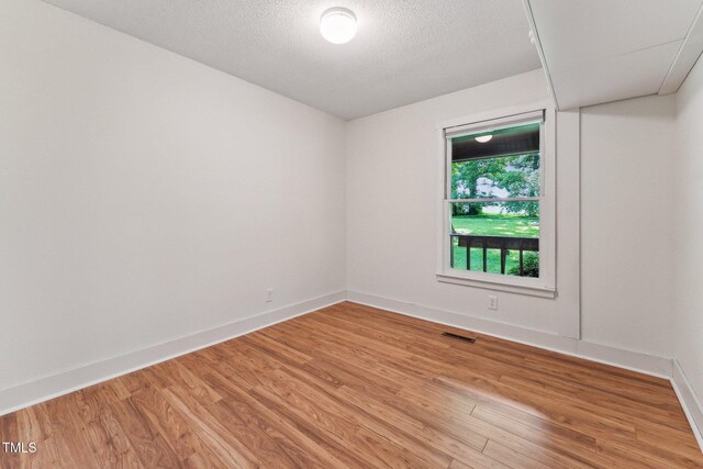 6971 Shady Creek Trl, Rougemont, NC 27572 - unfurnished room with light wood-style floors, baseboards, and a textured ceiling