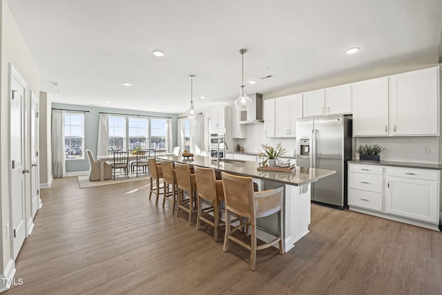 1247 Shaw View Aly Unit 201, Raleigh, NC 27601 - kitchen with stainless steel refrigerator with ice dispenser, a sink, wood finished floors, a breakfast bar, and recessed lighting