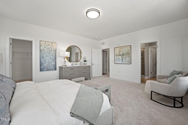 1247 Shaw View Aly Unit 201, Raleigh, NC 27601 - bedroom featuring a walk in closet, light colored carpet, a closet, and baseboards
