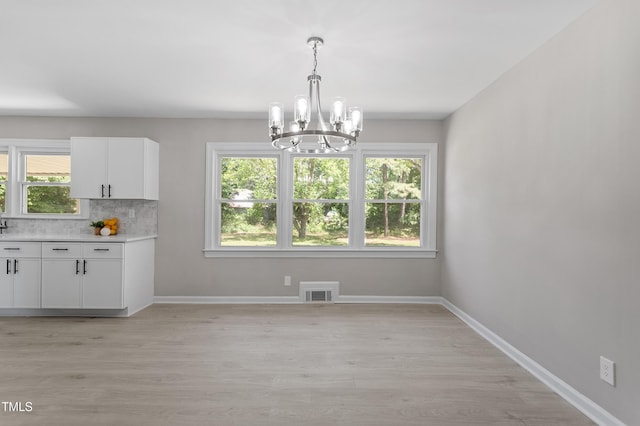 2003 Broadway Rd, Sanford, NC 27332 - unfurnished dining area featuring a chandelier, light wood finished floors, and baseboards