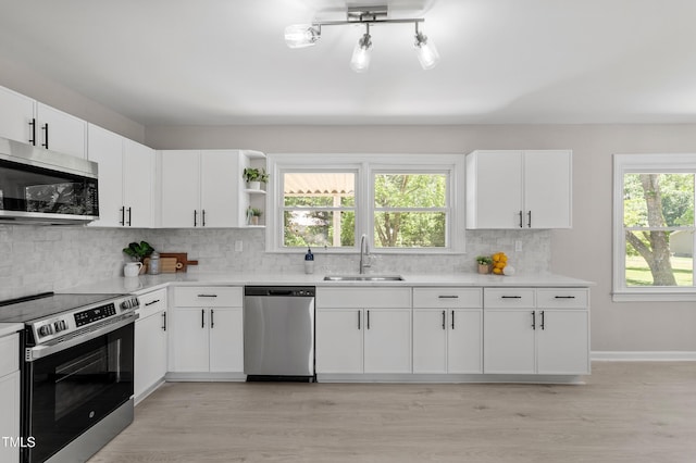 2003 Broadway Rd, Sanford, NC 27332 - kitchen with stainless steel appliances, a sink, light countertops, backsplash, and light wood-style floors
